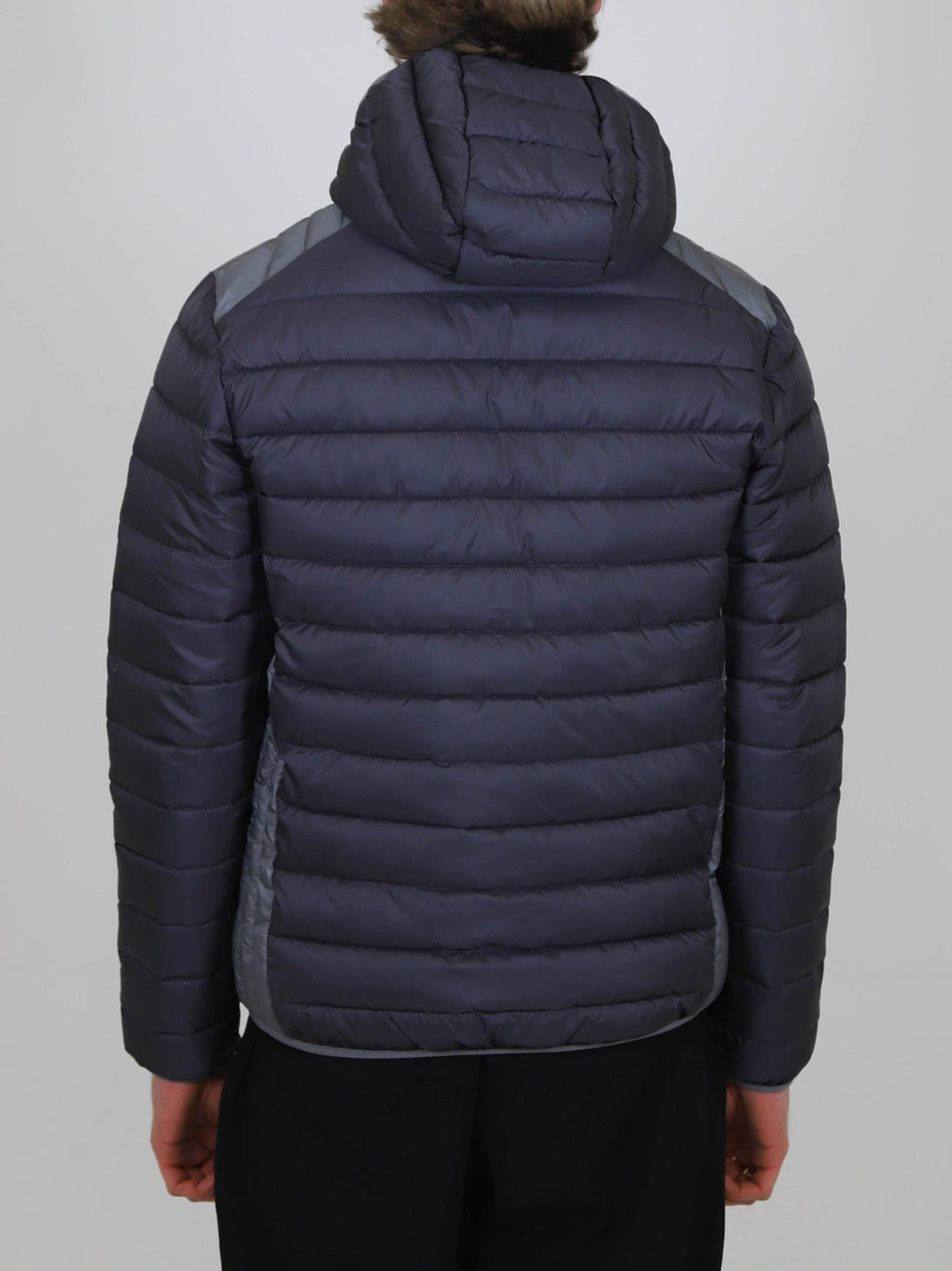 Back view of a person wearing a navy Winter Steep Padded Jacket with a hood and quilted design