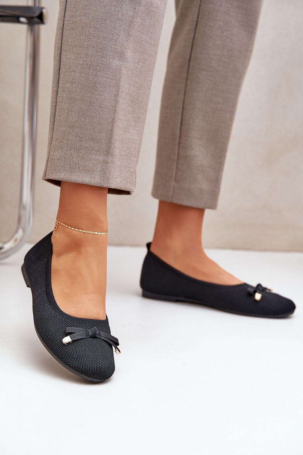 Women's black ballet flats with a small bow, mesh design, and eco-leather insole.