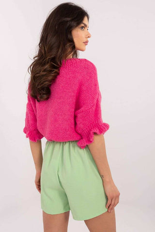 Stylish green skirt pants with high waist and wide legs, complemented by a pink knit top.
