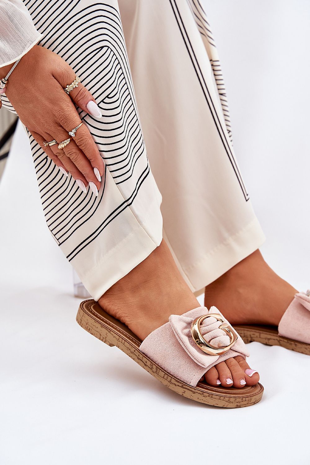 Beige flip-flops with faux suede and gold detail, perfect for warm weather.