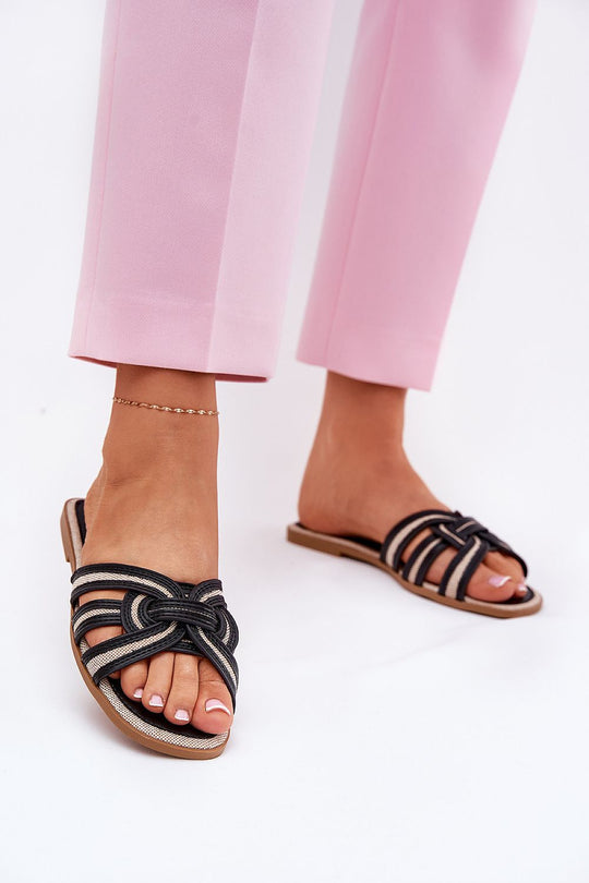 Flat Flip-flops with interwoven straps, eco leather and textile, worn with pink trousers.