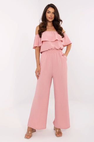 Pink off-shoulder jumpsuit with Carmen neckline and ruffle detail, elastic waist, and wide-leg pants.