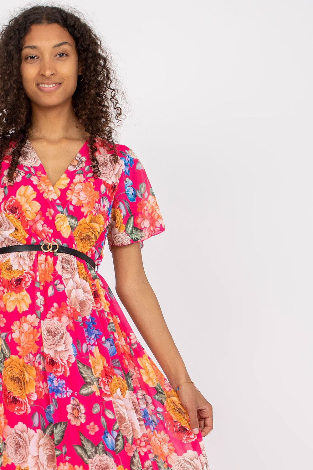 Summer floral dress with envelope neckline, short sleeves, pleated hem, and belt.